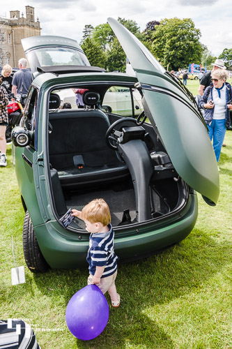 Tiny electric Microlino with little admirer