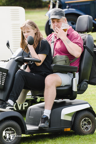Mobility scooter with girl 'pillion' and man with beer & fag